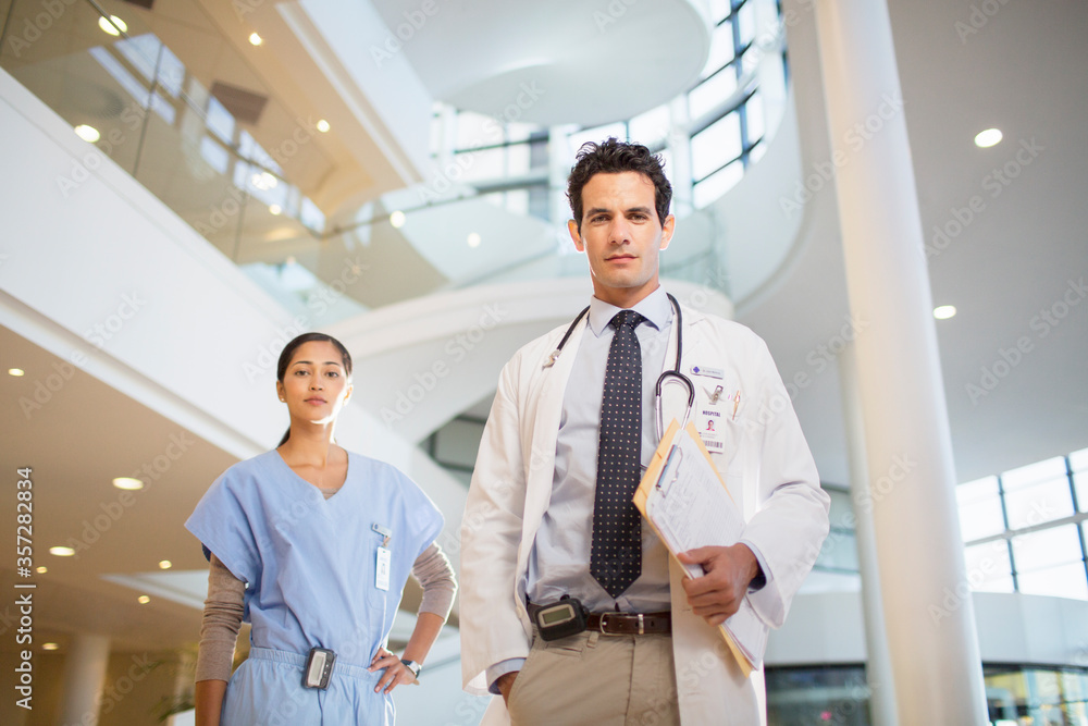 Φωτογραφία Portrait of confident doctor and nurse in hospital atrium