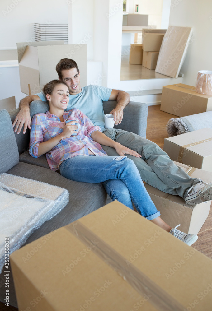 Couple relaxing with coffee on sofa in new house Couple relaxing with coffee on sofa in new house