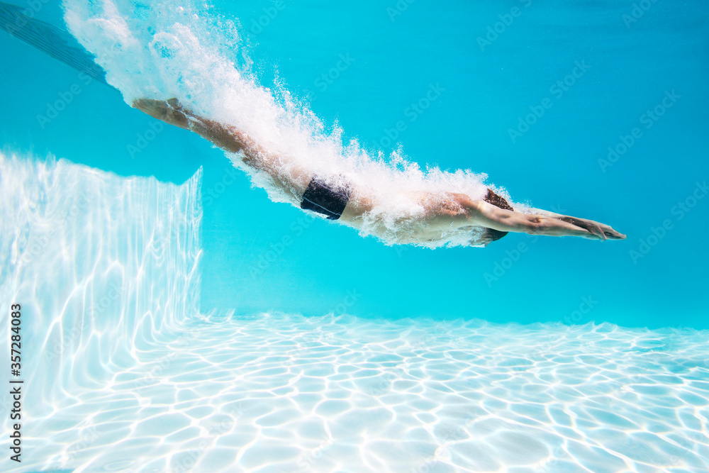 Man diving into swimming pool - obrazy, fototapety, plakaty 