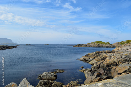 majestic ocean landscape with many small rocky islands and mountain backdrop photo