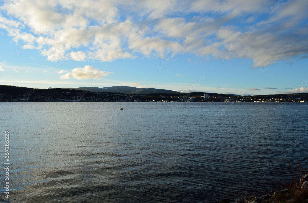 blue fjord and sun over tromsoe city island in late autumn