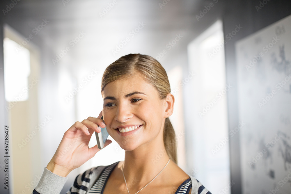 Businesswoman talking on cell phone in office Businesswoman talking on cell phone in office