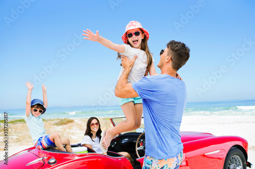 Father lifting daughter from convertible at beach © Dan Dalton/KOTO