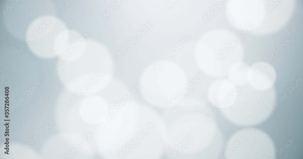 White particles bokeh with blurred depth of field. Moving floating particle animation. Seamless Loop.