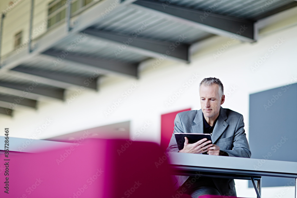 Businessman using digital tablet in lobby Businessman using digital tablet in lobby