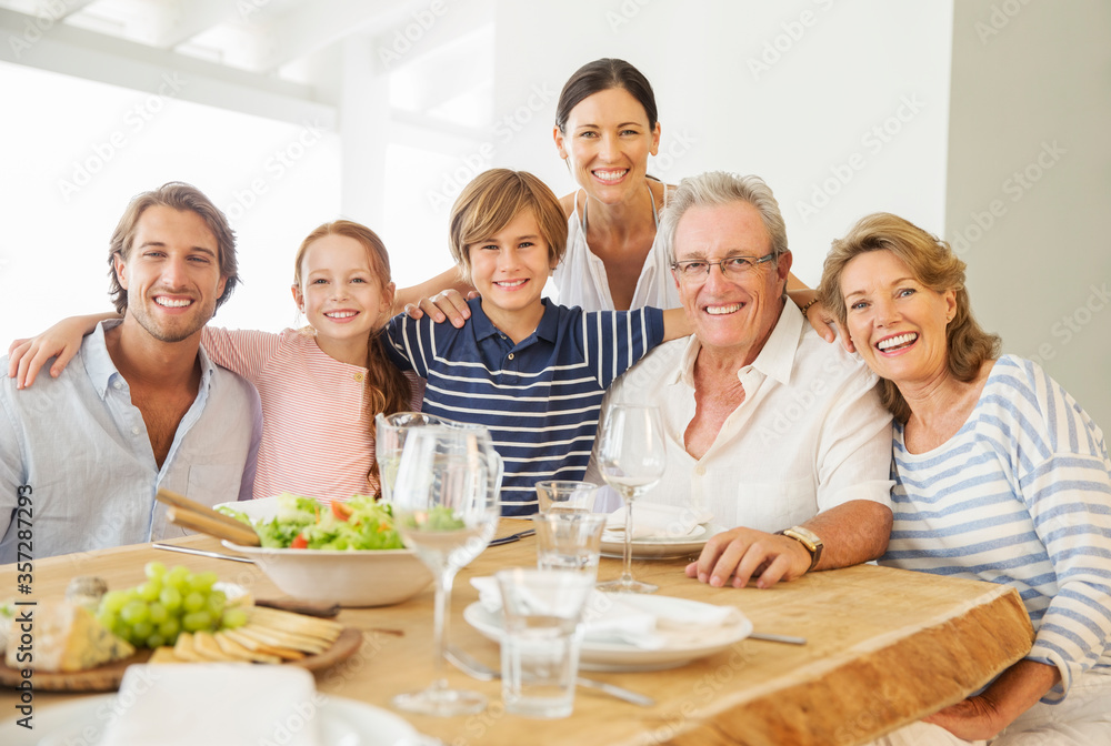 Multi-generation family smiling together at table Multi-generation family smiling together at table
