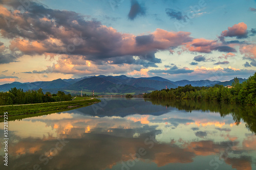 Mirroring of the mountainous landscape on the water surface of the dam at sunset. Zilina dam in the north of Slovakia, Europe.