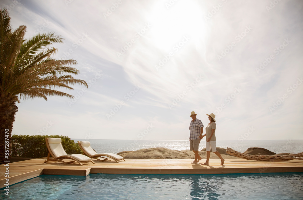 Older couple relaxing together by pool Stock Photo | Adobe Stock
