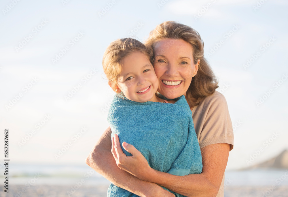 Grandmother and granddaughter hugging on beach Grandmother and granddaughter hugging on beach