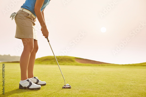 Woman putting on golf course