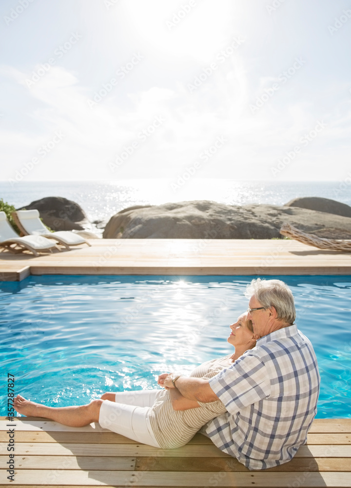 Older couple relaxing by pool