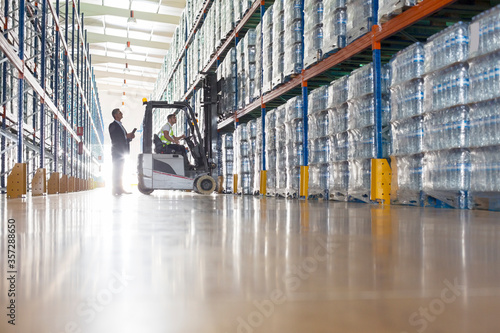 Workers with forklift in bottling warehouse