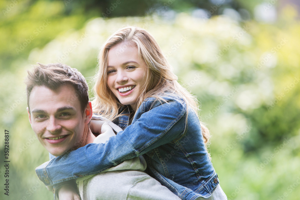 Man carrying girlfriend piggyback outdoors Man carrying girlfriend piggyback outdoors