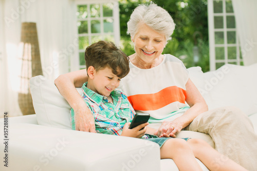 Older woman and grandson using cell phone