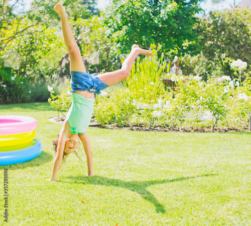 Girl doing cartwheels in backyard photo