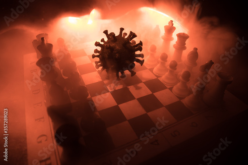 Big Corona virus miniature model on chessboard with fog and backlight. Creative artwork decoration. Selective focus