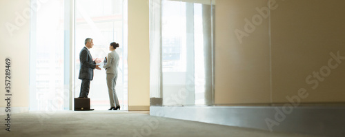 Business people talking at office window