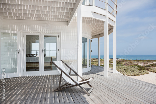 Fényképezés Deck chair on deck overlooking beach