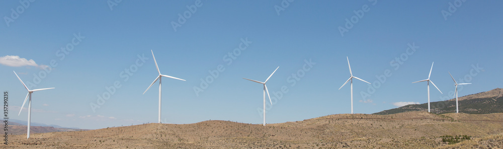 Wind turbines spinning in rural landscape Wind turbines spinning in rural landscape