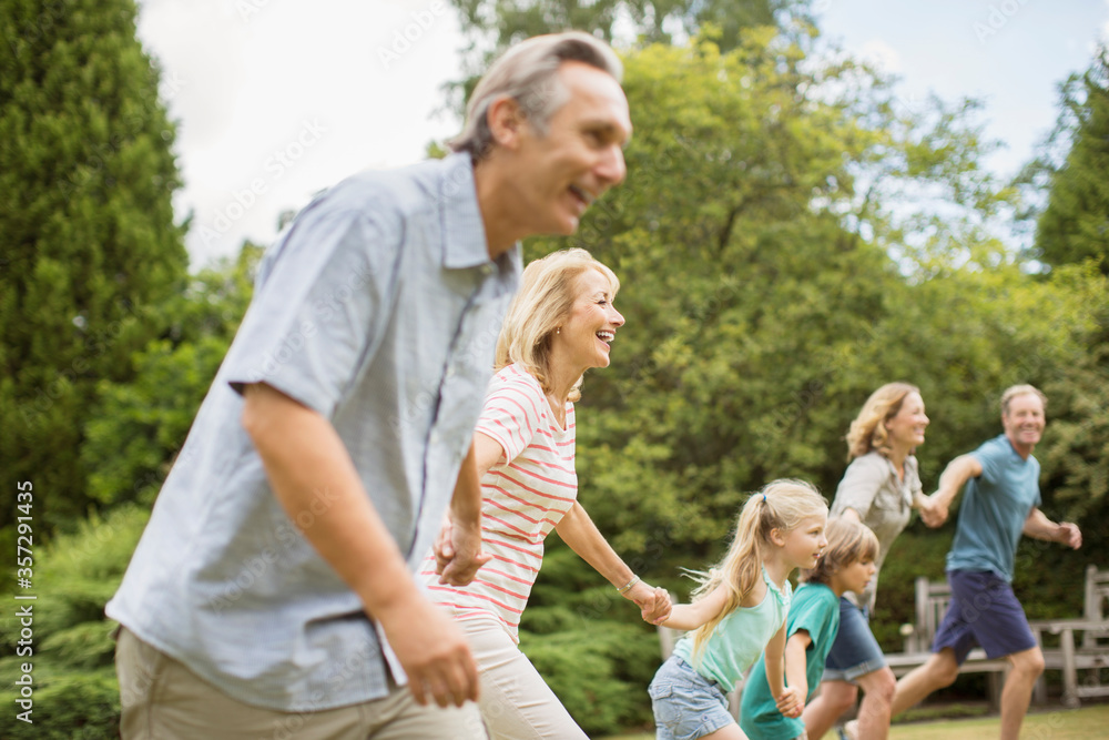 Multi-generation family holding hands and running Multi-generation family holding hands and running