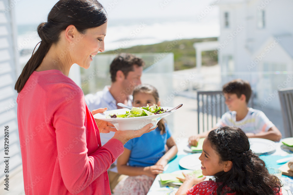 Family eating lunch at table on sunny patio Family eating lunch at table on sunny patio
