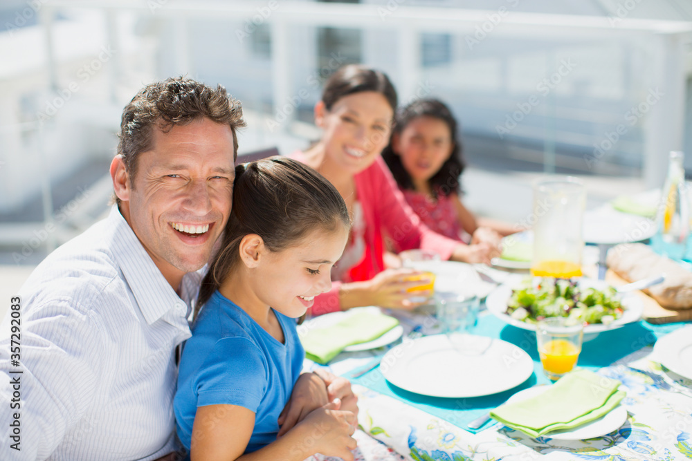 Family eating lunch at table on sunny patio
