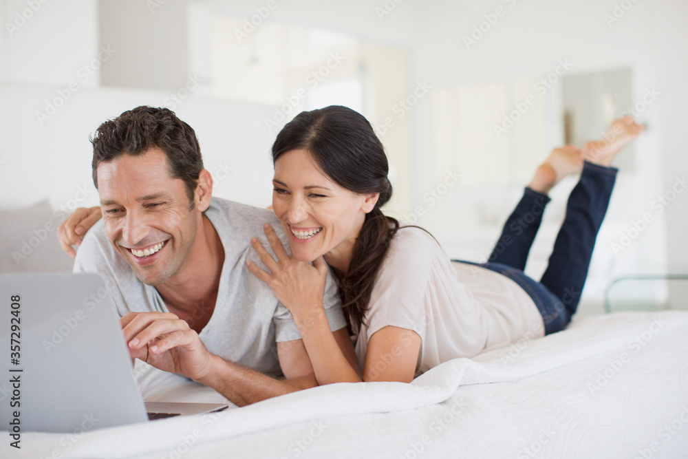 Couple using laptop on bed Couple using laptop on bed
