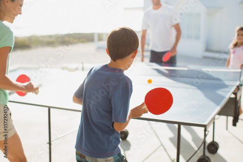 фотографія Family playing table tennis together outdoors