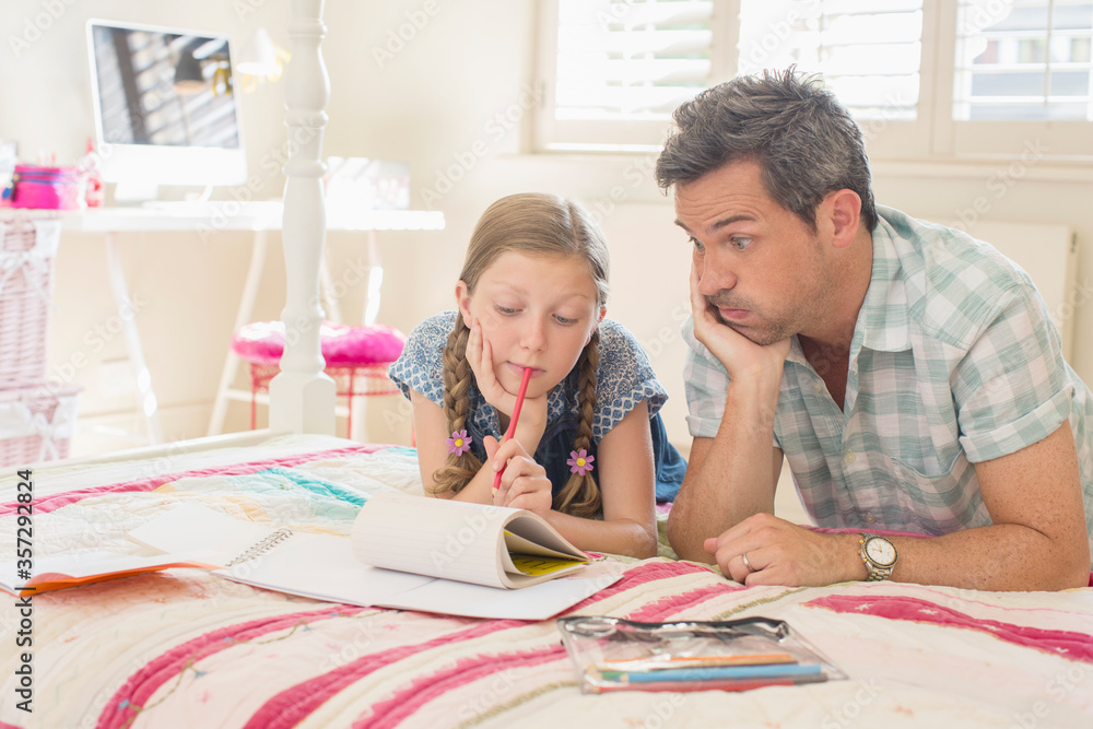 Father helping daughter with homework Father helping daughter with homework