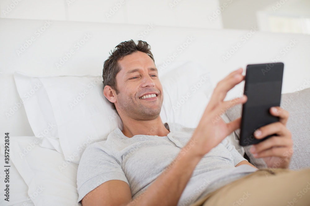 Man using digital tablet in bed Man using digital tablet in bed