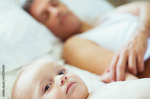 Father and baby laying on bed