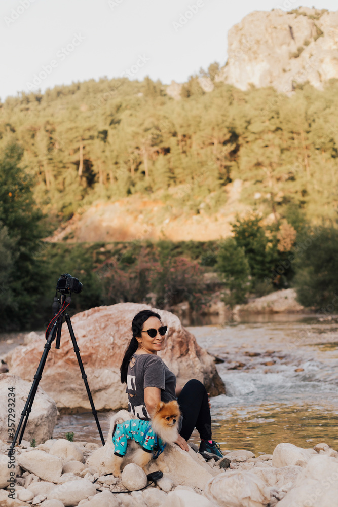 Photographer woman taking photos in nature with her dog