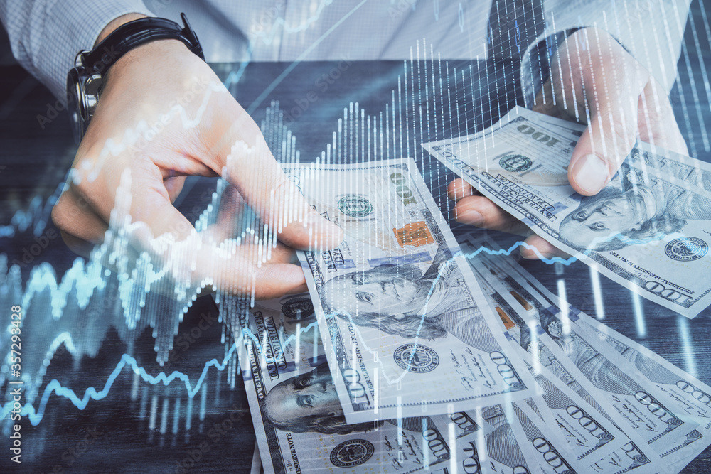 Multi exposure of financial graph drawing hologram and USA dollars bills and man hands. Analysis concept. Multi exposure of financial graph drawing hologram and USA dollars bills and man hands. Analysis concept.