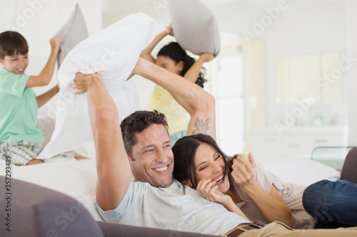 Family enjoying pillow fight in living room
