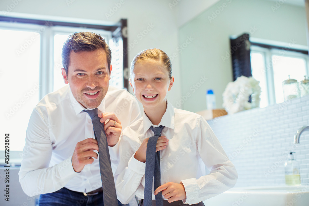 Obraz premium Father and daughter adjusting ties in bathroom
