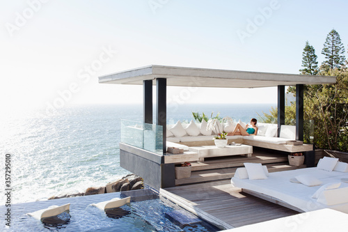 Woman relaxing in cabana overlooking ocean
