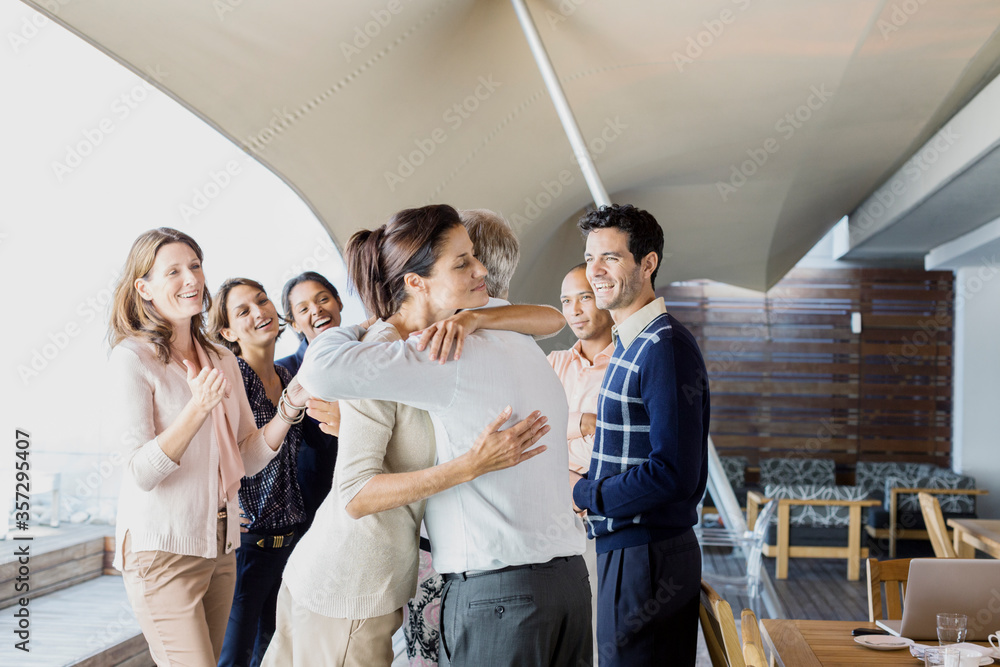 Business people hugging in office Business people hugging in office