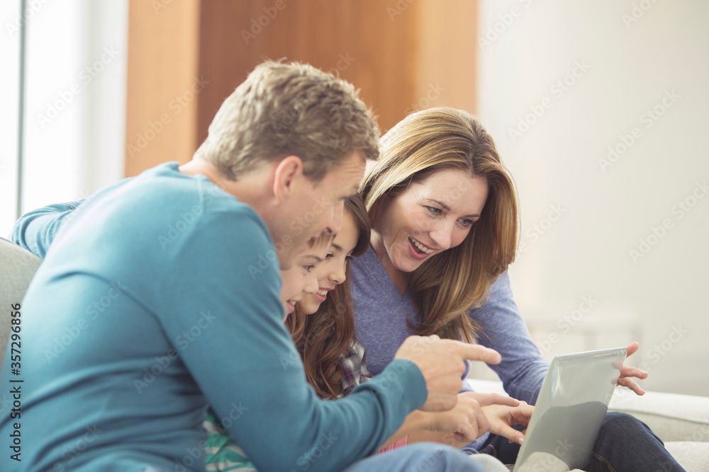 Family using laptop in living room Family using laptop in living room