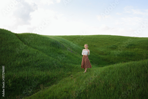 Girl walks on the green hills. High quality photo