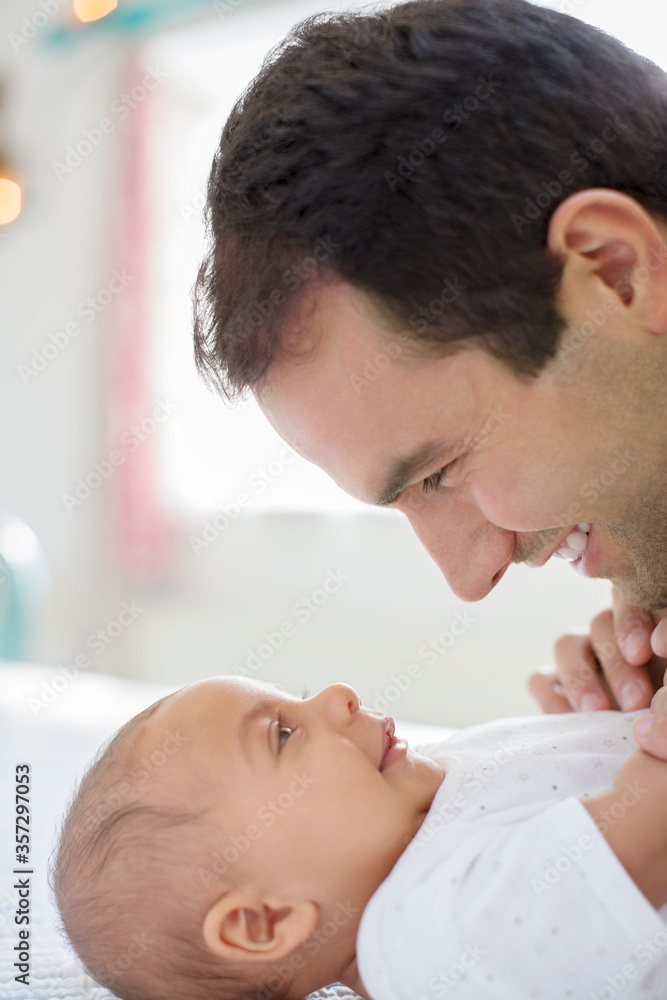Father adoring baby boy on table