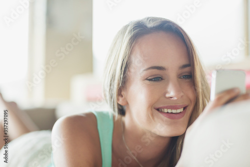 Close up of smiling woman texting with cell phone