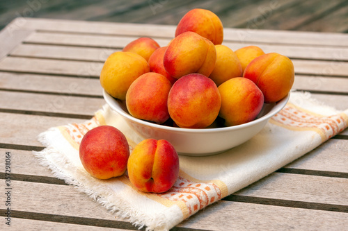 peaches in a bowl on wooden table