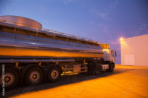 Stainless steel milk tanker parked at night