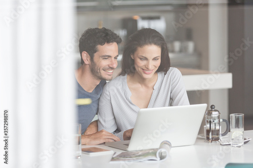 Couple using laptop at table