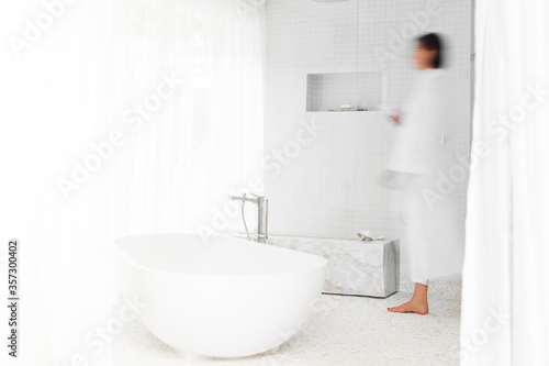 Blurred view of woman walking in modern bathroom