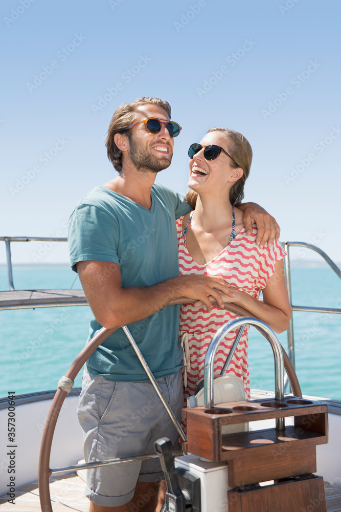 Couple steering boat together 