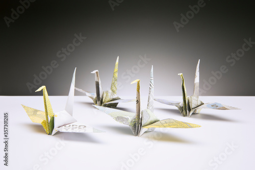 Origami cranes made of Euros on counter