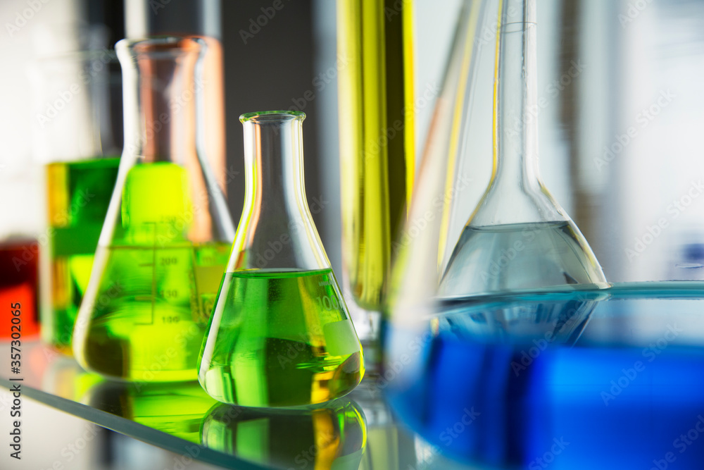 Close up of beakers with solutions on shelf in lab Close up of beakers with solutions on shelf in lab