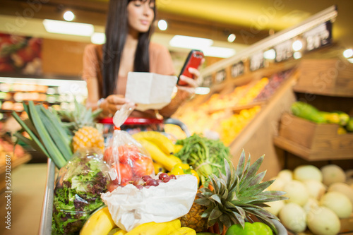 Woman checking shopping list in grocery store photo