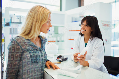 Woman discussing product with pharmacist in drugstore